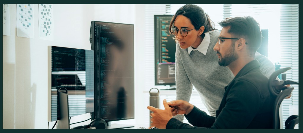 Two people collaborating at a computer in an office
